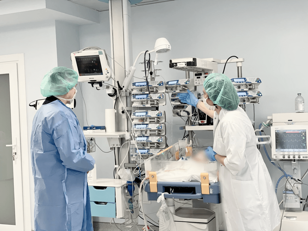 Лікарі стоять біля дитини та перевіряють показники на моніторах пацієнта