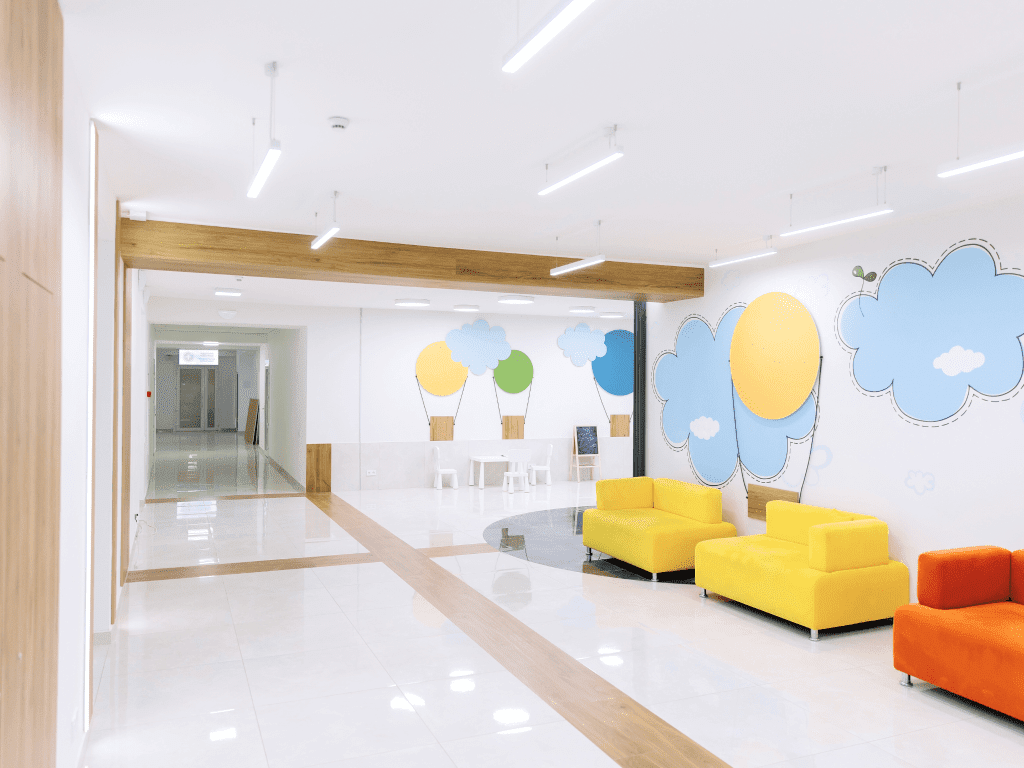 Світлий хол Лікарні Святого Миколая з кольоровими диванами та малюнками на стінах